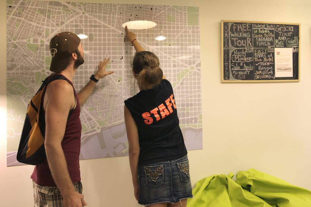 Gracia City Hostel บาร์เซโลนา ภายนอก รูปภาพ Hostel staff helping a guest with a map